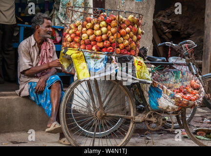 Man selling apples from his bicycle on a street in Kathmandu Stock Photo