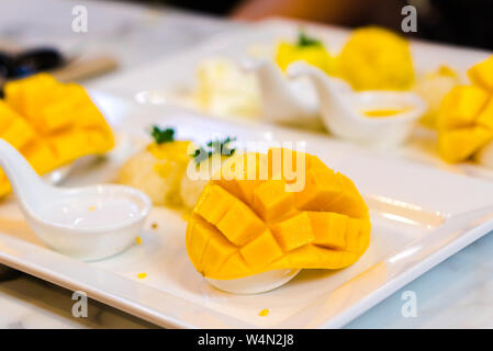 Mango sticky rice in a white dish with selected focus mango. Stock Photo