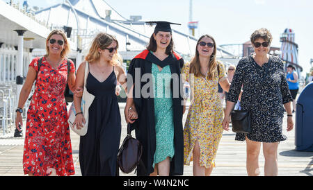 Brighton UK 24th July 2019 - Mathilde Compagnon celebrates graduating from the University of Sussex with a stroll with family and friends on Brighton Palace Pier as the hot sunny weather continues throughout Britain . The heatwave conditions are forecast to continue tomorrow  and temperatures are expected to hit new records with it reaching as high as 39 degrees celsius in London . Credit: Simon Dack / Alamy Live News Stock Photo