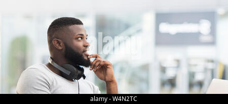 Thoughtful african man sitting in a cafe and looking away Stock Photo