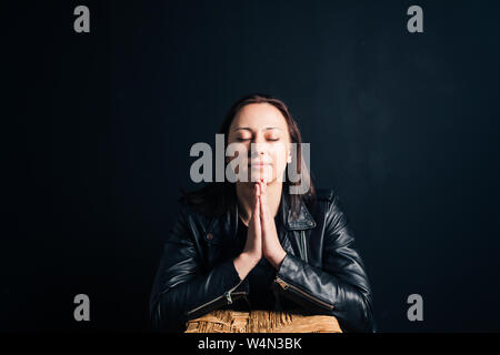 Studio portrait of an attractive young woman in a black leather jacket against a plain background Stock Photo