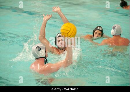 A Johns Hopkins Blue Jays Men's Water Polo player raises his arms to block a pass while participating in a game against Bucknell University, October 16, 2009. From the Homewood Photography Collection. () Stock Photo