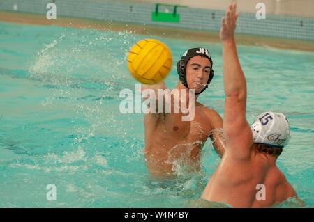 A Johns Hopkins Blue Jays Men's Water Polo player throws the ball while participating in a game against George Washington University, October 9, 2009. From the Homewood Photography Collection. () Stock Photo