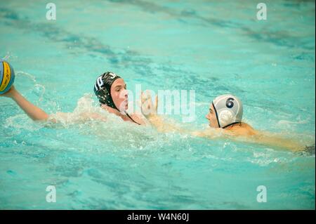 A Johns Hopkins Blue Jays Men's Water Polo player holds the ball in one hand, while defending against a competitor, during a game with Bucknell University, September 24, 2010. From the Homewood Photography Collection. () Stock Photo