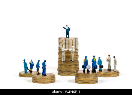 Miniature business people on stacks of coins. Business concept. Macro photo Stock Photo