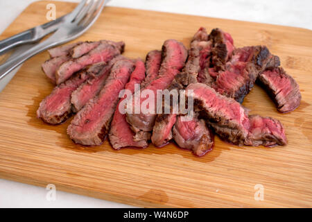 Sliced Rare Steak on a Cutting Board Stock Photo