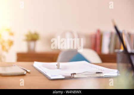 Folder with paper questionnaire on wooden table in office. Horizontal composition. Front view. Stock Photo