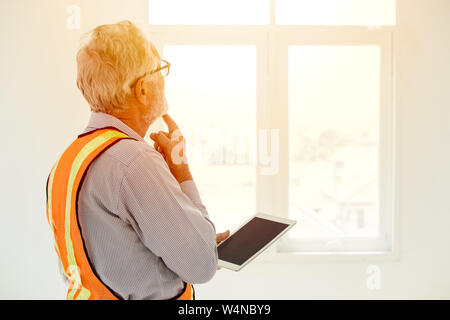 senior engineer thinking project looking at windows handle tablet for future development concept Stock Photo