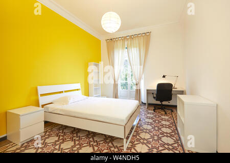 Bedroom with large bed and desk in renovated apartment Stock Photo