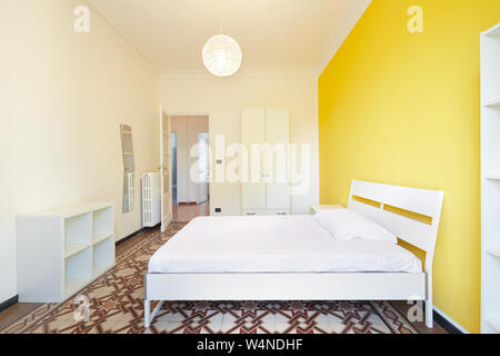 Renovated bedroom in apartment for rent with white and yellow walls Stock Photo