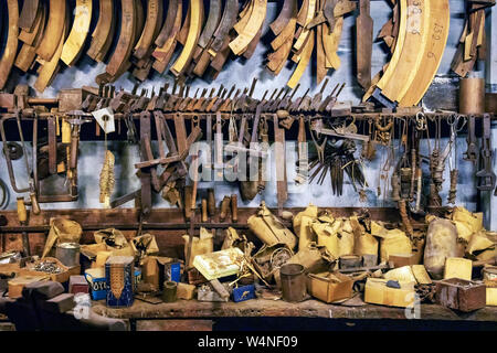 Old vintage carpenter tools on the wall and bench in the workshop.- Image Stock Photo