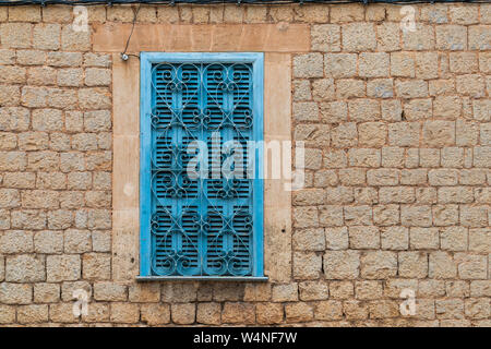 Turquoise window shutters with heart-shaped window grating in a brick wall facade in Valldemossa, Majorca, Spain - head-on view, landscape format, cop Stock Photo