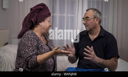 elderly spouses quarreling, gesticulating, bad mood. Medium shot Stock Photo