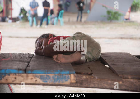 Street boy sleeps on a wooden platform. Stock Photo