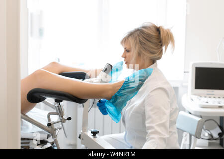 doctor obstetrician gynecologist examines a young pretty pregnant woman ...