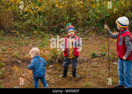 three small boys play together in a prairie in autumn Stock Photo