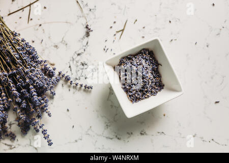 Dried lavender buds in ceramic bowl on kitchen counter Stock Photo