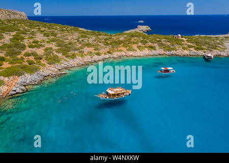 Aerial drone view of traditional Greek wooden boats floating on the crystal clear waters of the Aegean Sea (Crete) Stock Photo