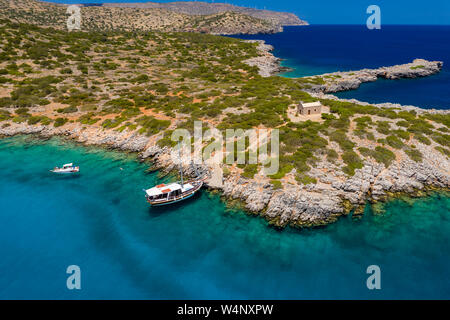 Aerial drone view of traditional Greek wooden boats floating on the crystal clear waters of the Aegean Sea (Crete) Stock Photo