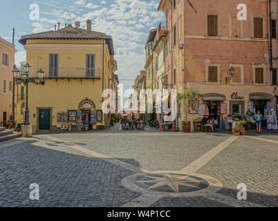 Castel Gandolfo, Lazio, Italy - August 29, 2017: View of the main square of the town of Castel Gandolfo, with some souvenirs and cafes in the street Stock Photo