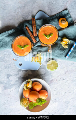 Refreshing cold drink, apricot smoothie with mango and physalis Stock Photo