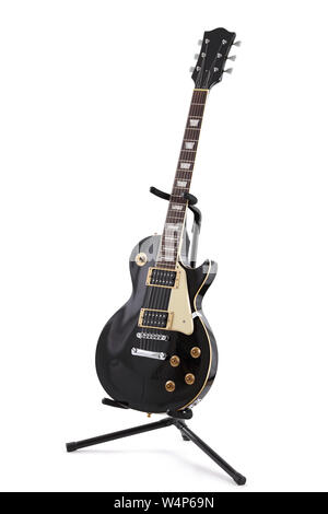 A black electric guitar on a stand isolated on white with clipping path Stock Photo