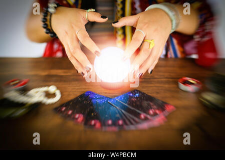 Psychic readings and clairvoyance concept / Crystal ball fortune teller hands and Tarot cards reading divination Stock Photo