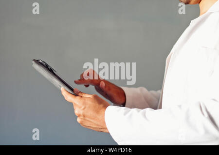Doctor dressed in white using a tablet. Stock Photo