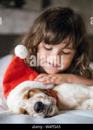 English setter puppy with santa claus hat and little girl smiling Stock Photo