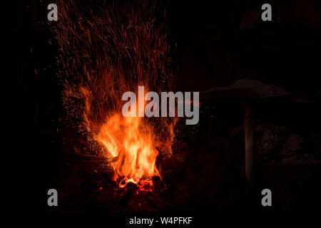 Traditional blacksmith furnace with burning fire Burning fire in furnace at forge, workshop. Blacksmith equipment concept Stock Photo