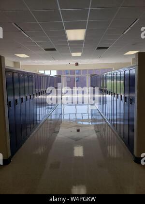 A bank of blue student lockers in a clean middle school hallway. Stock Photo
