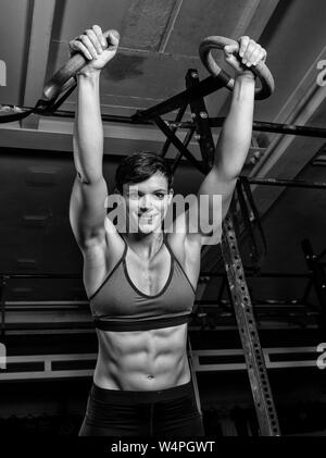 Portrait of an athletic beautiful woman with strong abs in a gym