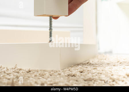 Assembling furniture at home / assembly of the table / modern light interior in detail Stock Photo