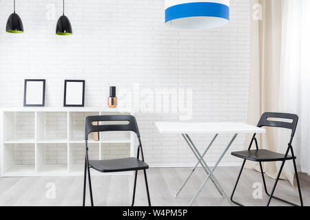 Clean modern interior with empty bookcase, table and two chairs Stock Photo