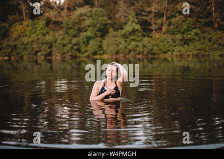 Young woman emerging from water