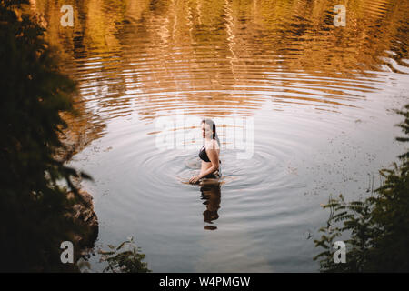 Young woman in a bikini standing in lake Stock Photo