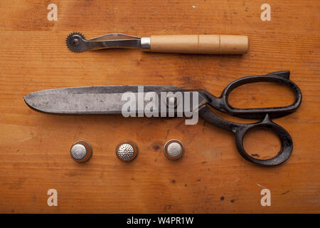 dressmaker shears craft concept with polw and thimble on wooden texture Stock Photo