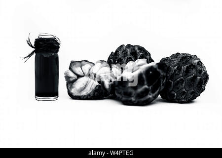 Organic floral essence of custard apple or sitaphal or sugar apple in a small transparent bottle isolated on white used in many flavored beverages wit Stock Photo