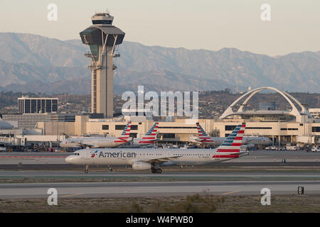 American Airlines jets shown at the Los Angeles International Airport, LAX, in Southern California. Note the control tower and Theme Building. Stock Photo