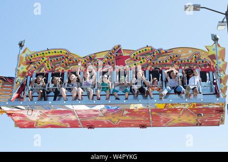 People riding an amusement park ride at a county fair in Oregon, USA. Stock Photo