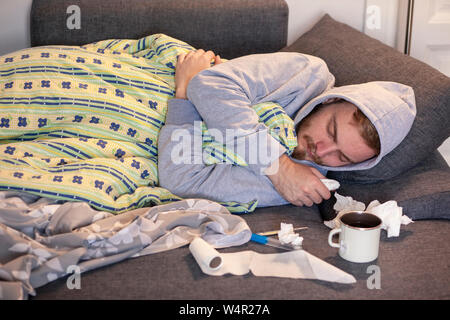 One young man, sleeping in bed, feeling sick. Stock Photo