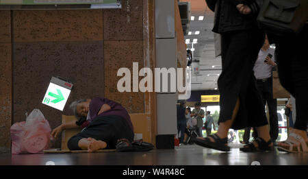 July 24, 2019, Taipei, Taiwan: An apparently homeless lady lays inside Taipei's Main station during in Taiwan during a hot and humid day. Around the Taipei Main Station are many homeless people who are very easy to spot. Taipei is the capital and a special municipality of Taiwan. Located in the northern part of the island of Taiwan. According to Wikipedia, the city is home to an estimated population of 2,704,810 people. In Taipei you can still see old structures and buildings, but the city also seems to be making very rapid progress in its modern infrastructure. Photograph taken on Wednesday Stock Photo