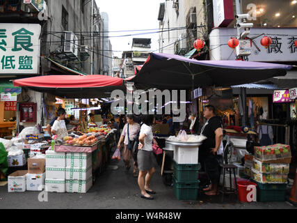 July 24, 2019, Taipei, Taiwan: People prepare food goods and fruits at an entrance of a local market place near Taipei Main station. Taipei is the capital and a special municipality of Taiwan. Located in the northern part of the island of Taiwan. According to Wikipedia, the city is home to an estimated population of 2,704,810 people. In Taipei you can still see old structures and buildings, but the city also seems to be making very rapid progress in its modern infrastructure. Photograph taken on Wednesday, July 24, 2019. Photo by: Ramiro Agustin Vargas Tabares. (Credit Image: © Ramiro Agustin Stock Photo