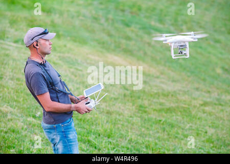 Young Man watching and navigating a flying drone Stock Photo