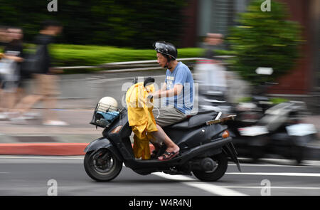 July 24, 2019, Taipei, Taiwan: A scooter rider can be seen at a local street near Taipei Main station. Taipei is the capital and a special municipality of Taiwan. Located in the northern part of the island of Taiwan. According to Wikipedia, the city is home to an estimated population of 2,704,810 people. In Taipei you can still see old structures and buildings, but the city also seems to be making very rapid progress in its modern infrastructure. Photograph taken on Wednesday, July 24, 2019. Photo by: Ramiro Agustin Vargas Tabares. (Credit Image: © Ramiro Agustin Vargas Tabares/ZUMA Wire) Stock Photo