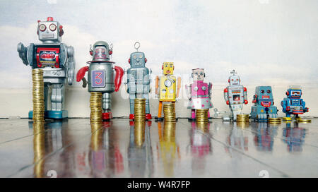 A line of retro toys with staks of gold coines on a wooden floor concept Stock Photo