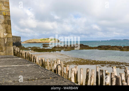 breakwater alignment of the piles In Oak, these wooden piles protect the city from the strength of the waves in Saint Malo France Stock Photo