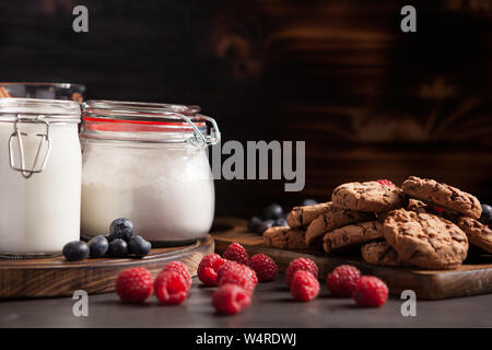 Delicious and freshly baked cookies stacked on wooden table. Tasty milk. Stock Photo