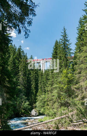 Langwies, GR / Switzerland - 24. July, 2015: the Rhaetian railway crosses the Langwies Viaduct over a deep canyon on the Chur - Arosa line Stock Photo