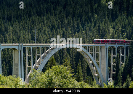 Langwies, GR / Switzerland - 24. July, 2015: the Rhaetian railway crosses the Langwies Viaduct over a deep canyon on the Chur - Arosa line Stock Photo